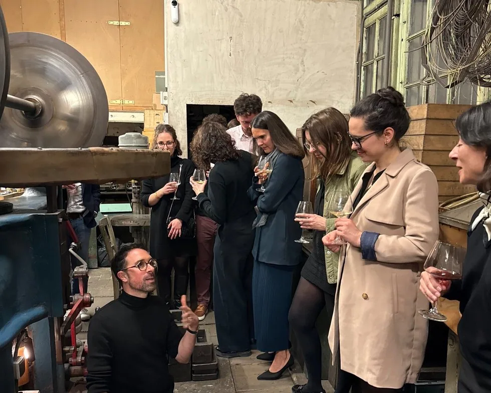 Des invités reçus dans un atelier d&rsquo;orfèvrerie, un verre à la main